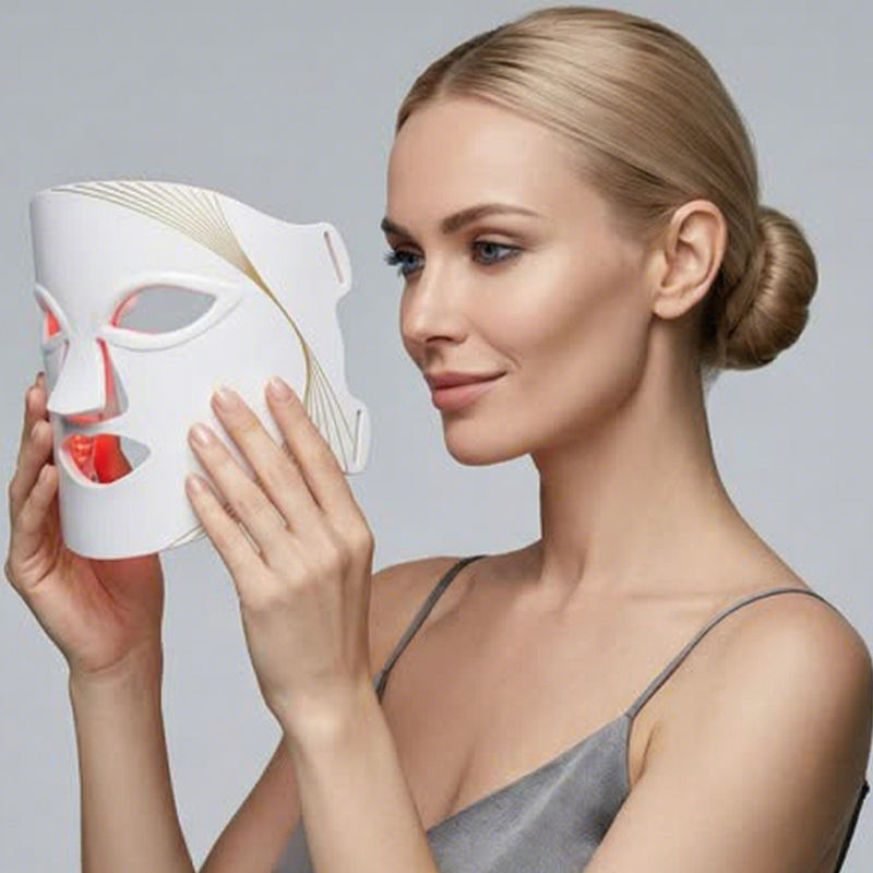 Woman holding the LUMINAE Glow Mask LED light therapy face mask